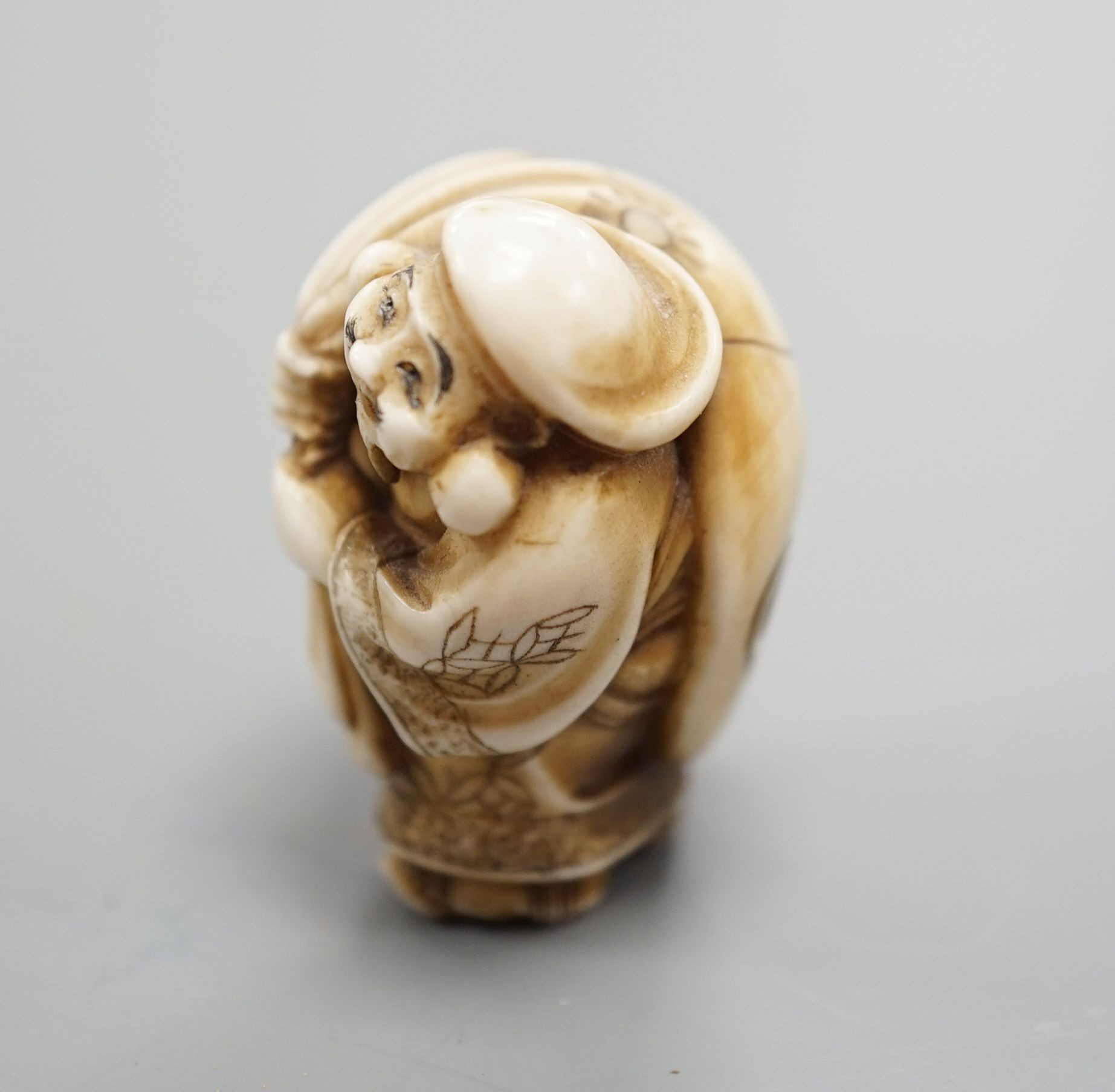 A Japanese ivory netsuke of Daikoku or Ebisu, Meiji period, 4 cms high.